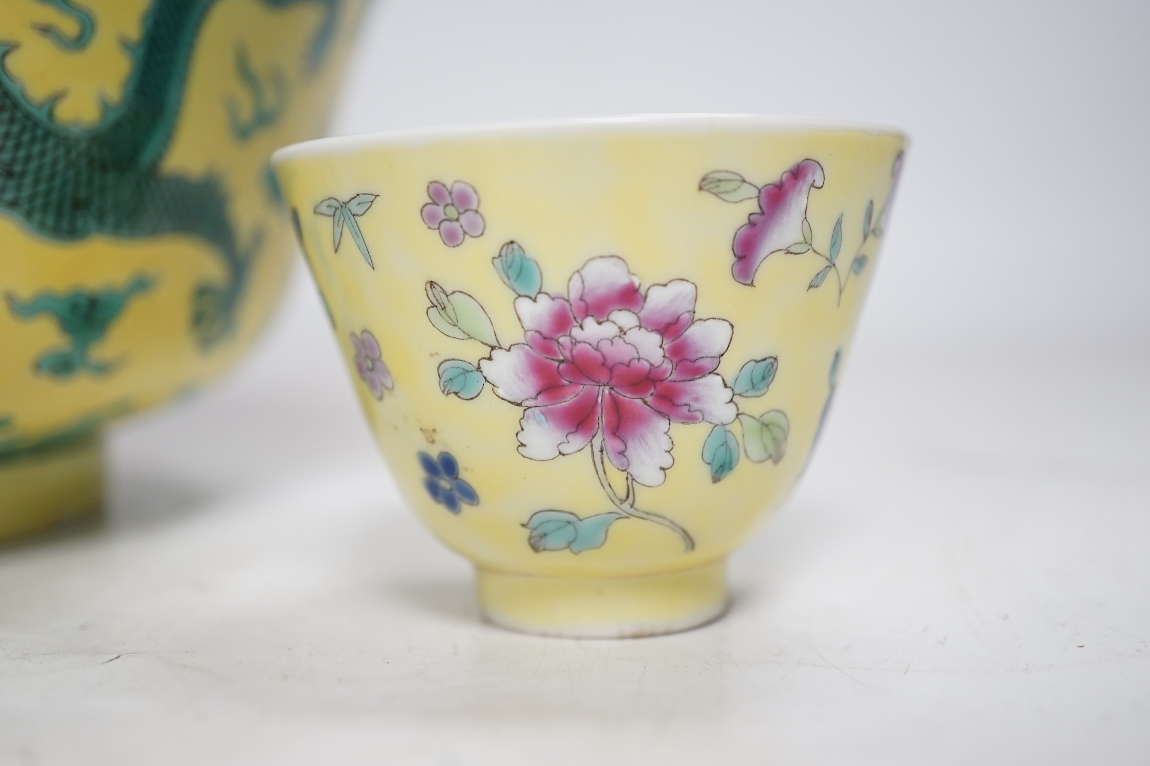 A Chinese yellow ground 'dragon' bowl, probably late Qing dynasty, and a similar floral cup, bowl 9cm high, 18.5cm diameter. Condition - bowl has a large section restored